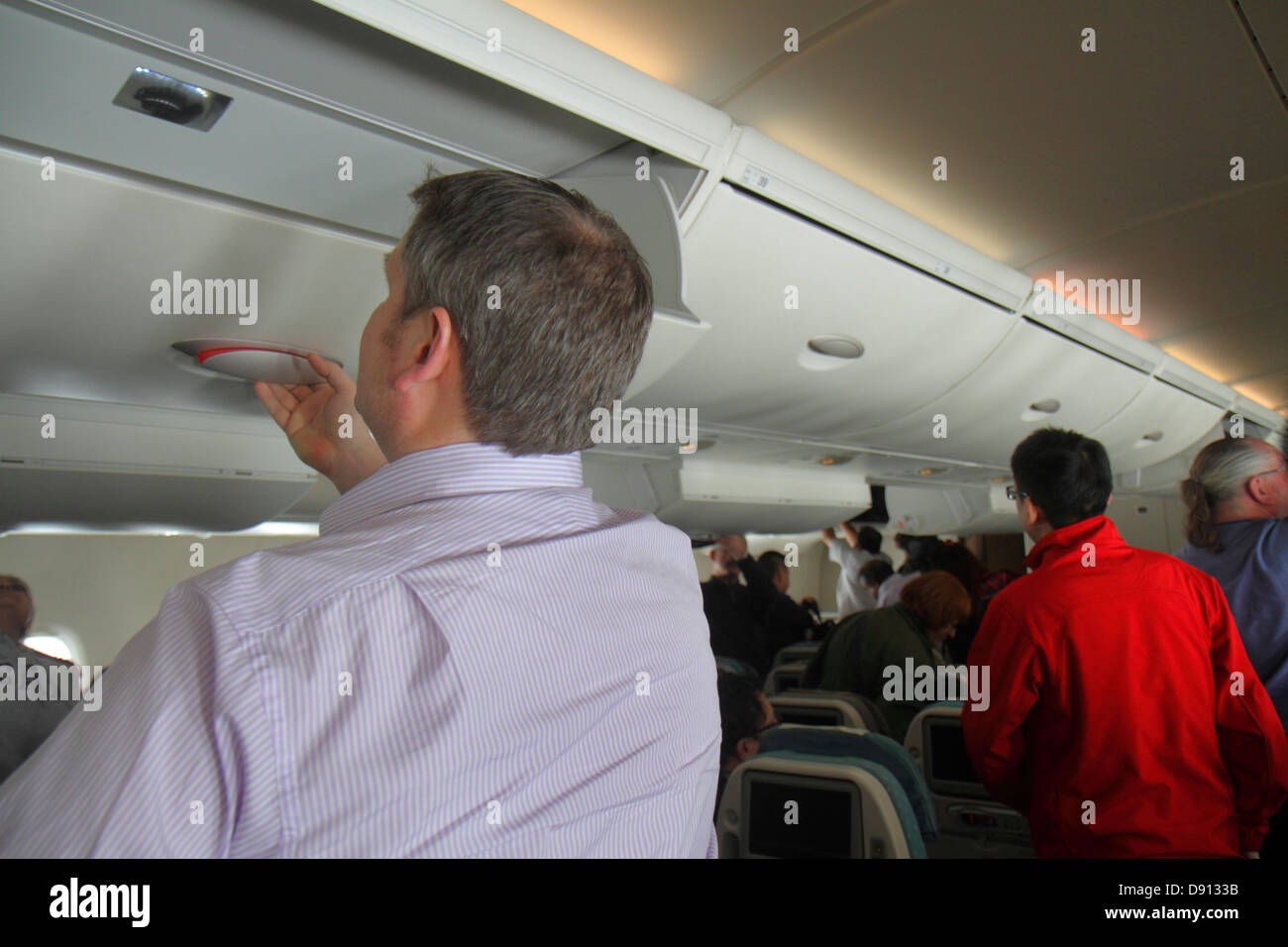 Singapore,Changi International Airport,SIN,inflight,passenger cabin,Singapore Airlines,arriving,passenger passengers rider riders,disembarking,overhea Stock Photo