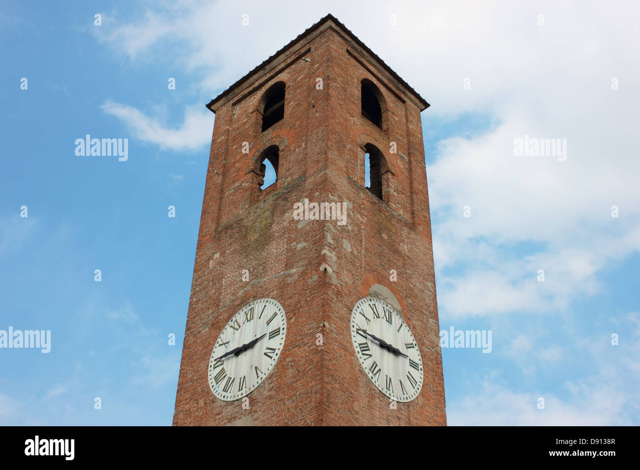 Antique clock tower in Lucca, Italy on blue sky background with white clouds. Stock Photo