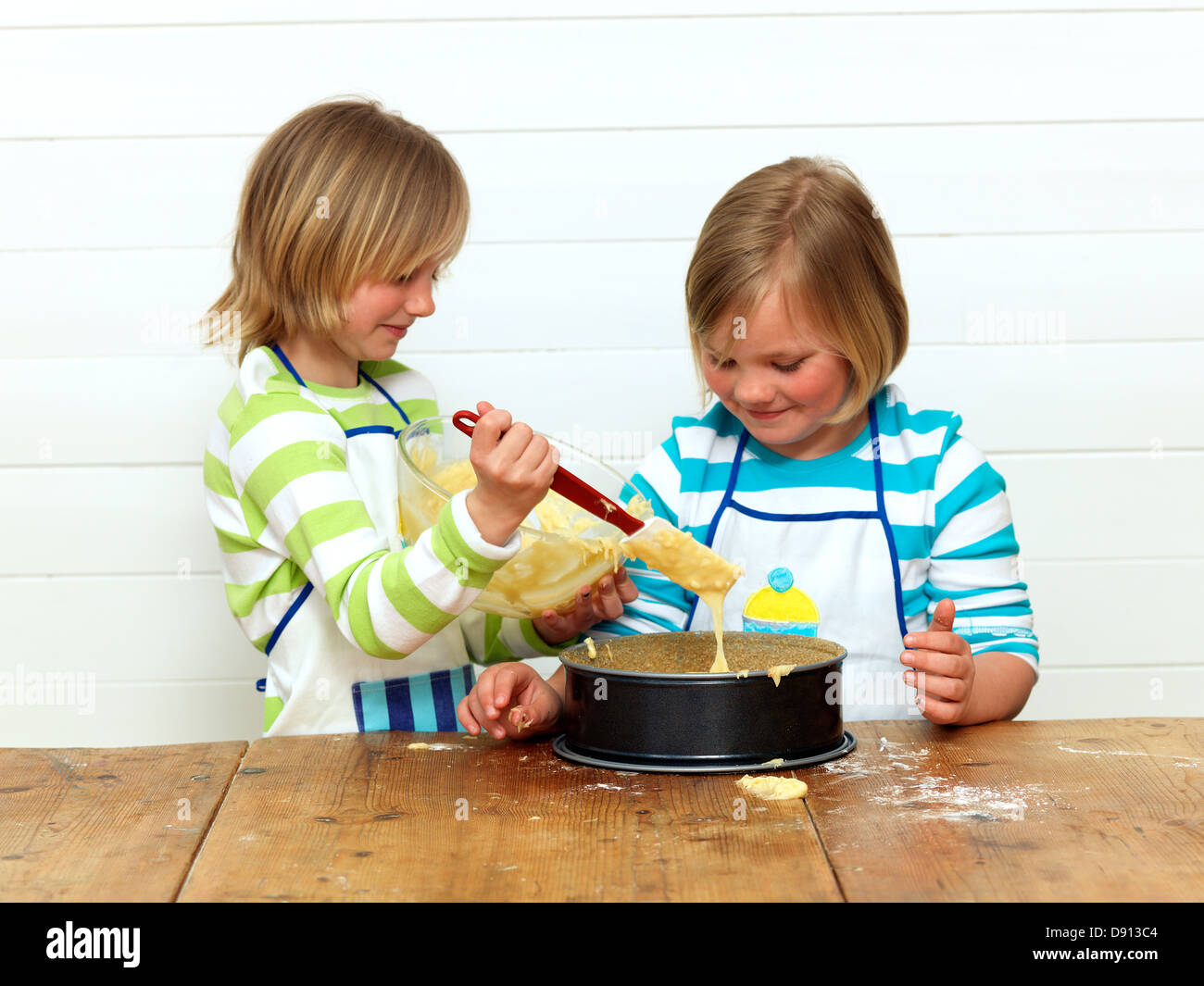 Two girls baking cake in kitchen Stock Photo Alamy