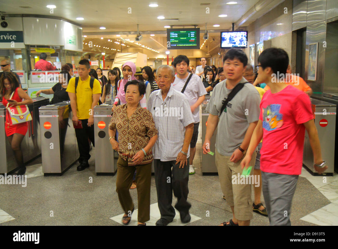 Singapore,City Hall MRT Station,East West Line,subway train,public transportation,Asian Asians ethnic immigrant immigrants minority,adult adults woman Stock Photo