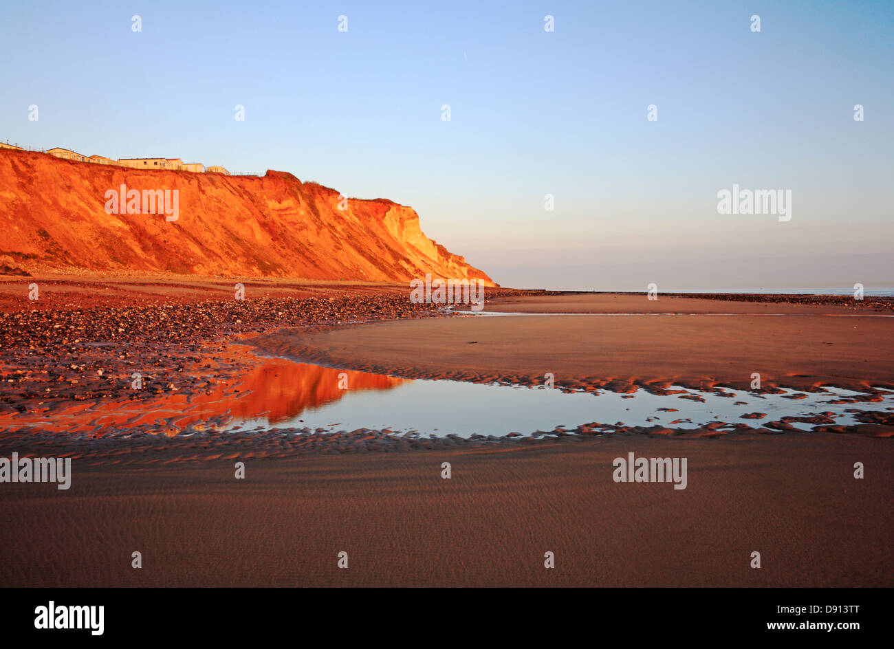 A view of the beach and cliffs with reflections in early morning sun at East Runton, Norfolk, England, United Kingdom. Stock Photo