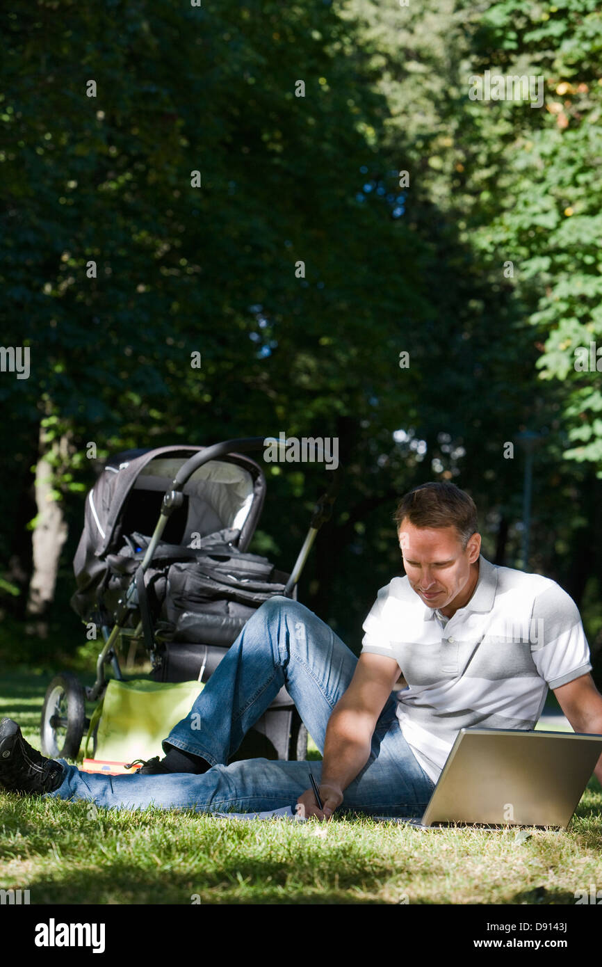 A man with a pram and a computer in a park a sunny day, Sweden Stock ...