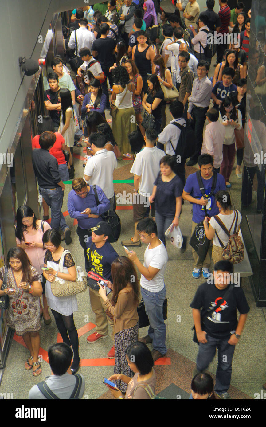 Singapore Dhoby Ghaut MRT Station,North South Line,subway train,platform,Asian man men male,woman female women,commuters,riders,waiting,Sing130201234 Stock Photo