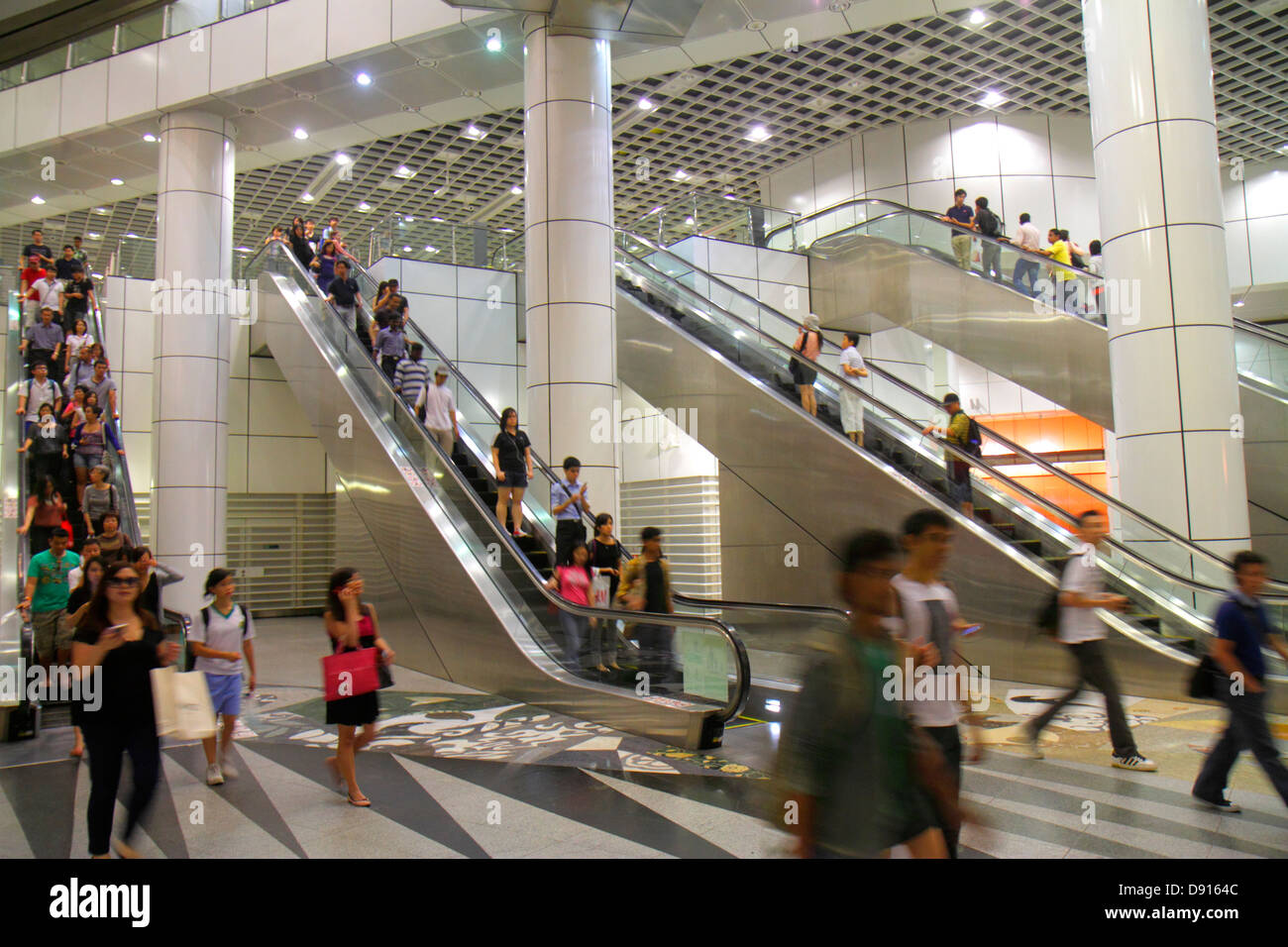 Singapore Dhoby Ghaut MRT Station,subway train,escalator,commuters,riders,Asian man men male,woman female women,Sing130201240 Stock Photo