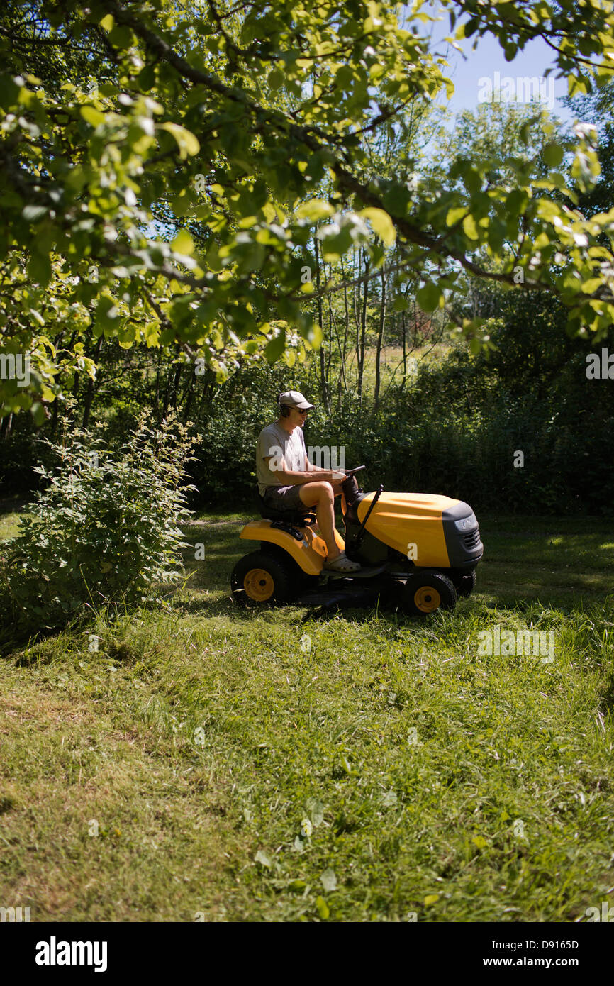 Mature man on riding-on lawn mower Stock Photo - Alamy