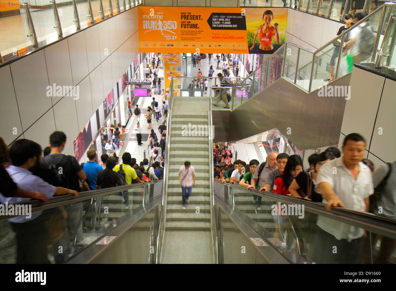 Singapore Dhoby Ghaut MRT Station,subway train,escalator,commuters,riders,Asian man men male,woman female women,platform,Sing130201245 Stock Photo