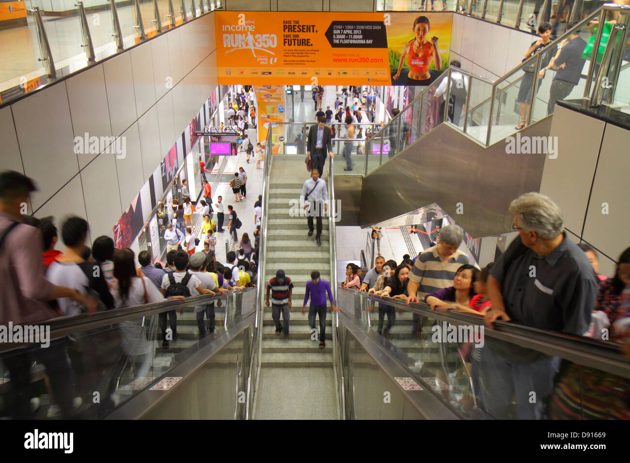 Singapore,Dhoby Ghaut MRT Station,subway train,public transportation,escalator,commuters,riders,Asian Asians ethnic immigrant immigrants minority,adul Stock Photo