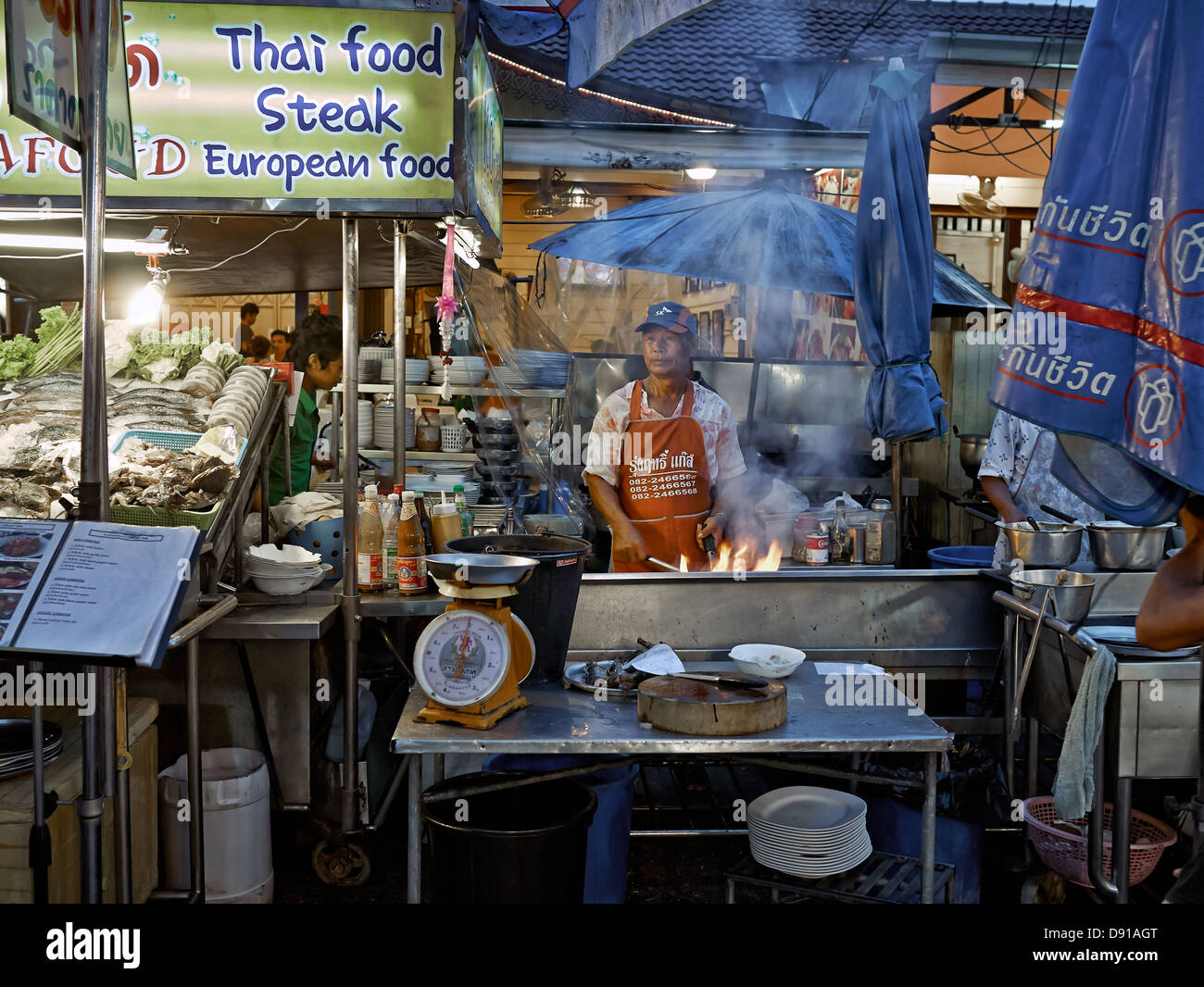Hua Hin night market with Thai chef cooking food on a live flame grill