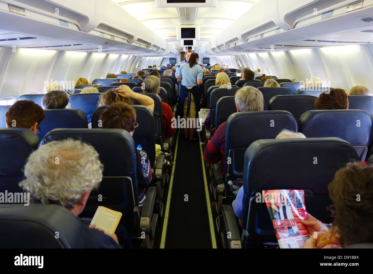 Passengers on a aeroplane, interior of seating area on aircraft, passengers in economy seats during flight Stock Photo