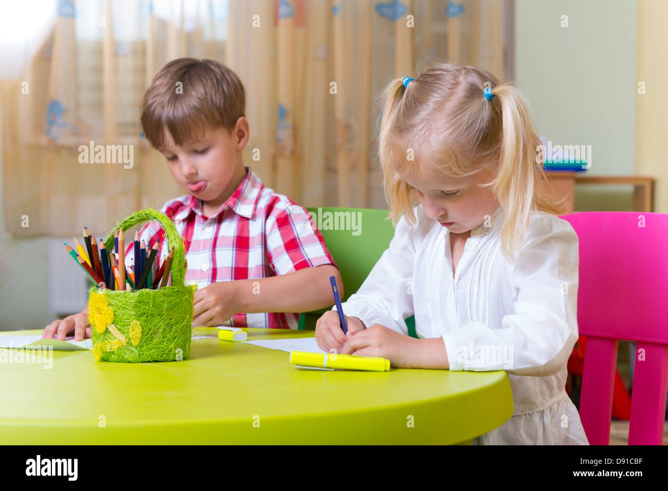 Two cute little prescool kids drawing with crayons at the table Stock ...