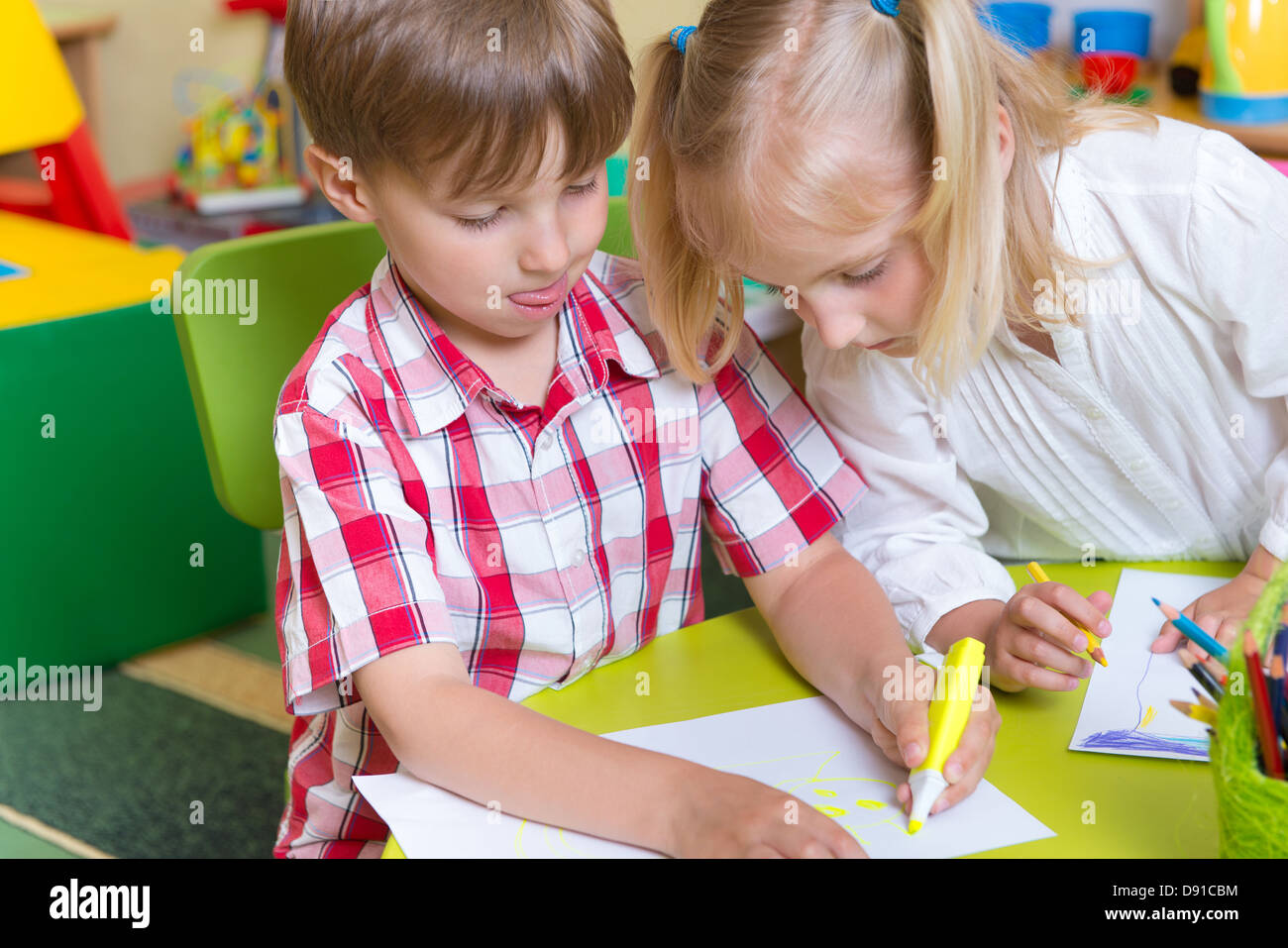 Two cute little prescool kids drawing with crayons at the table Stock ...
