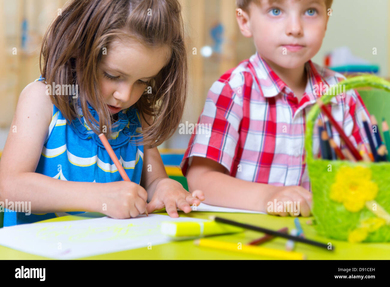 Two cute little prescool kids drawing with crayons at the table Stock ...