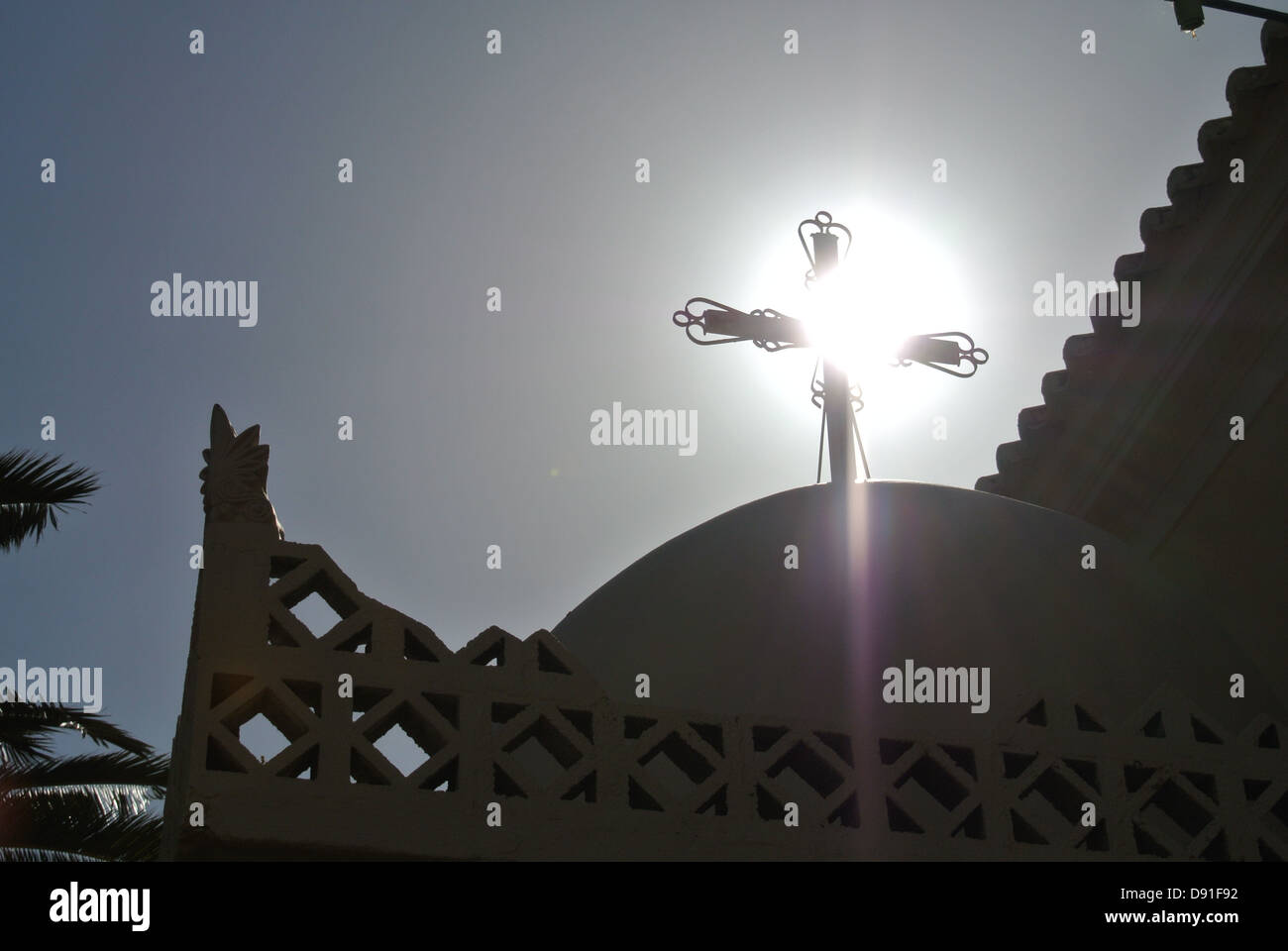 A holy cross upon a Greek Catholic Church blocking the clear summer sun, causing a messianic glow Stock Photo
