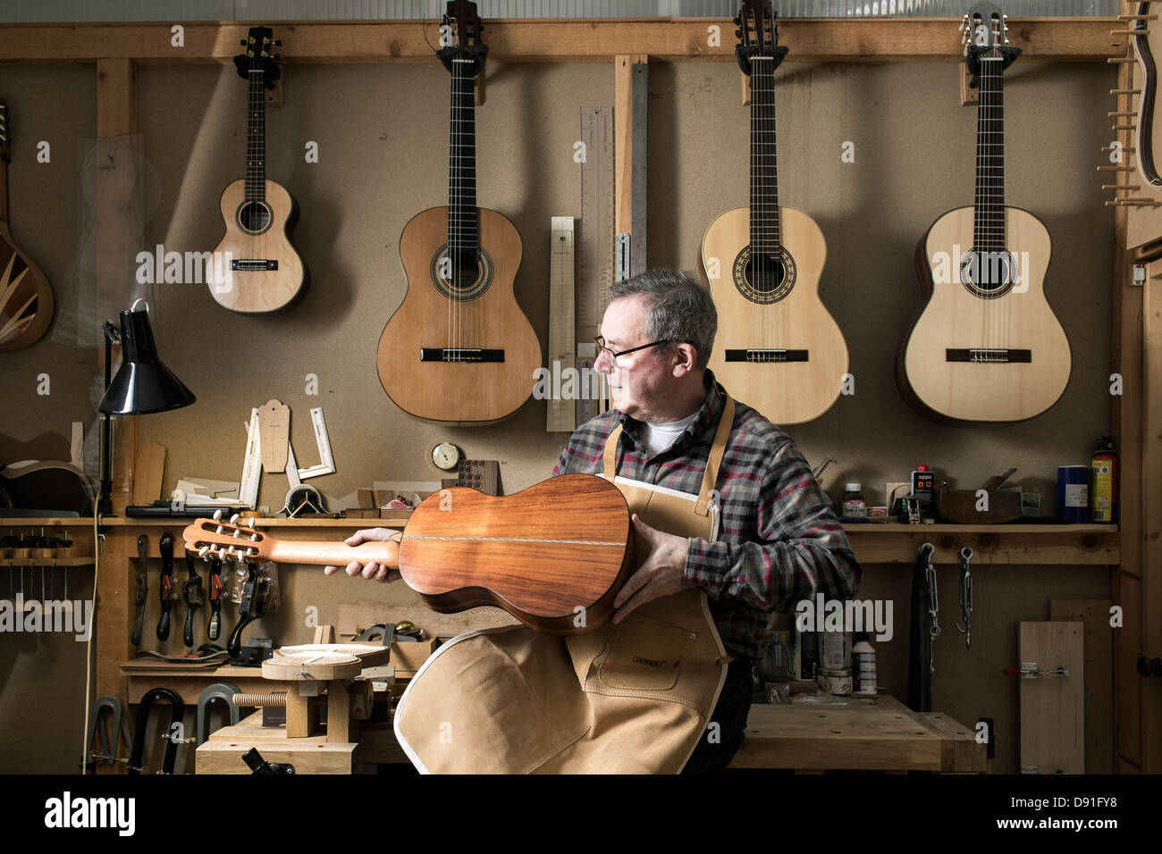 Guitar maker finishing acoustic guitar in Stock Photo Alamy