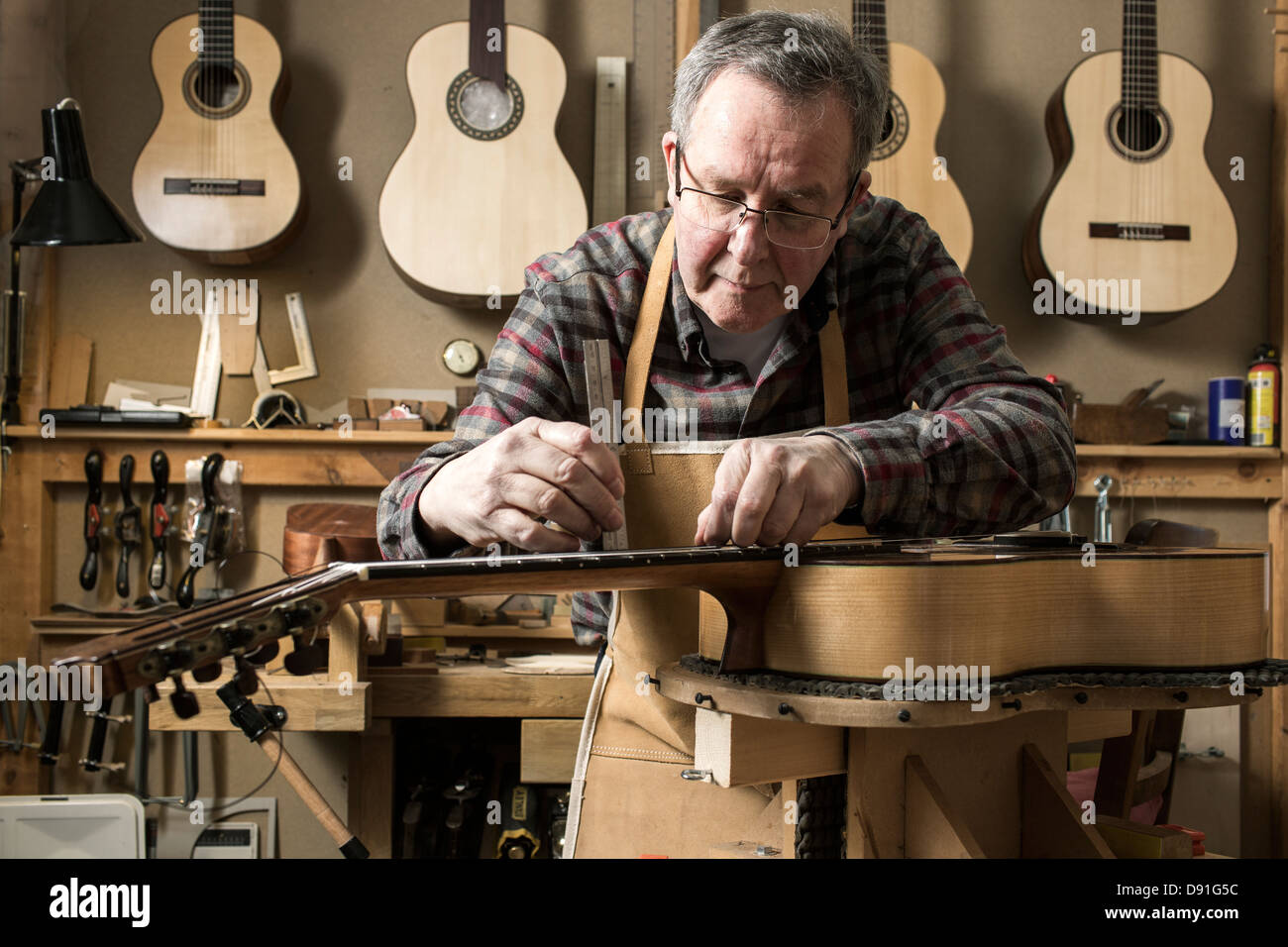Guitar maker finishing acoustic guitar in Stock Photo Alamy