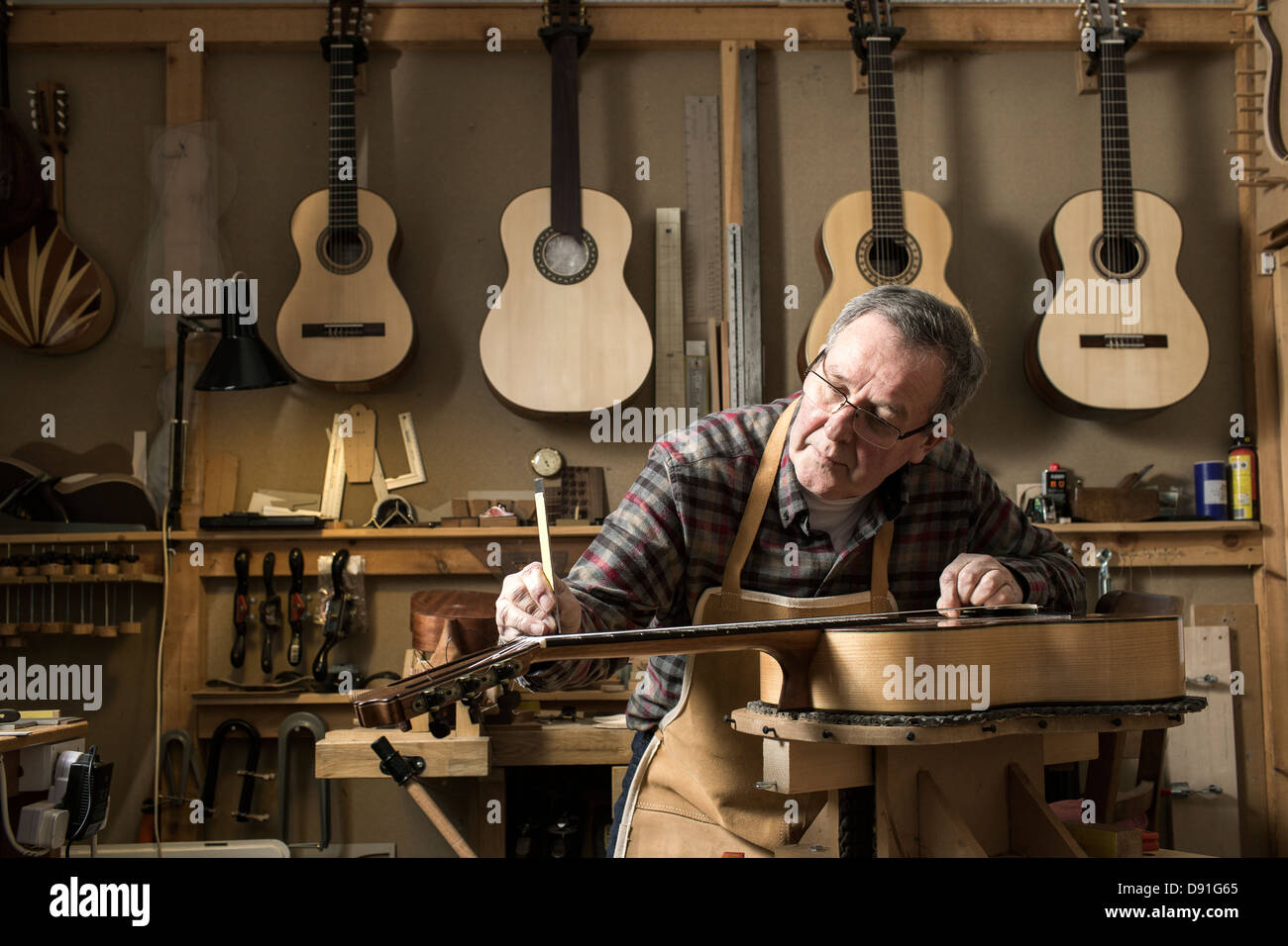 Guitar maker finishing acoustic guitar in Stock Photo Alamy