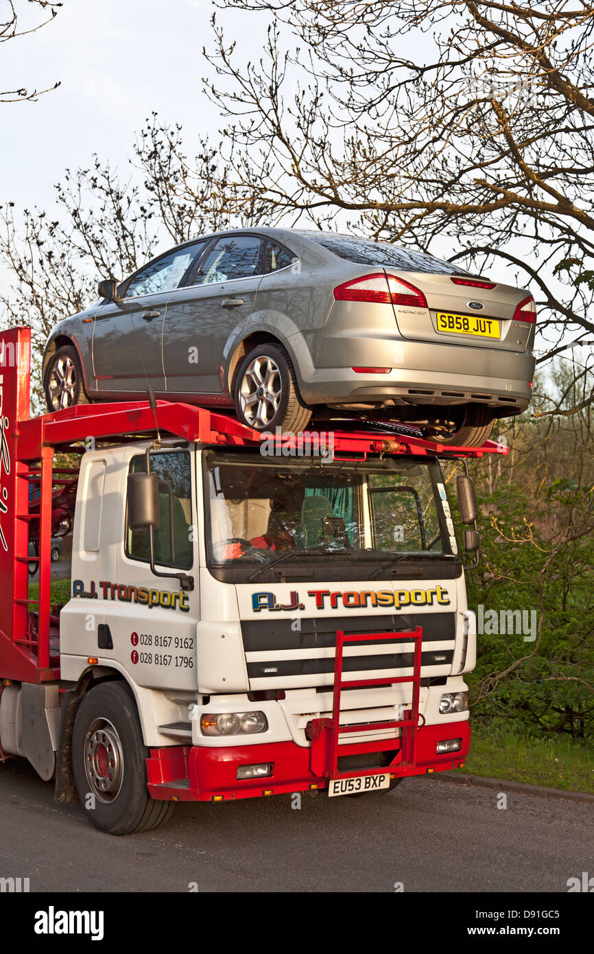 A Car transporter with a Ford Mondeo car secured above the cabin. Stock Photo