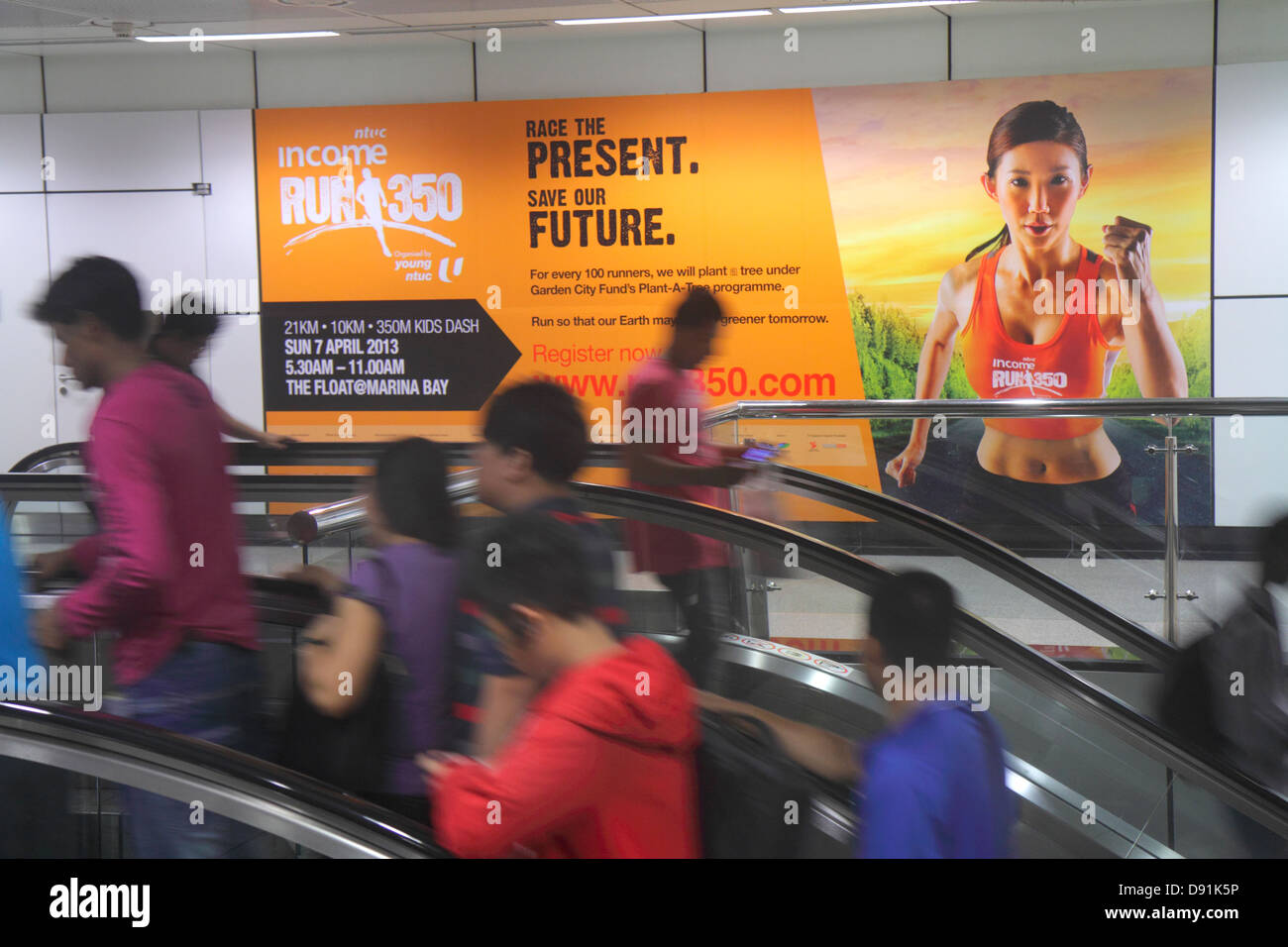 Singapore,Dhoby Ghaut MRT Station,North South Line,subway train,escalator,riders,commuters,billboard,advertisement,ad,ad,advertising,ad,Asian woman fe Stock Photo