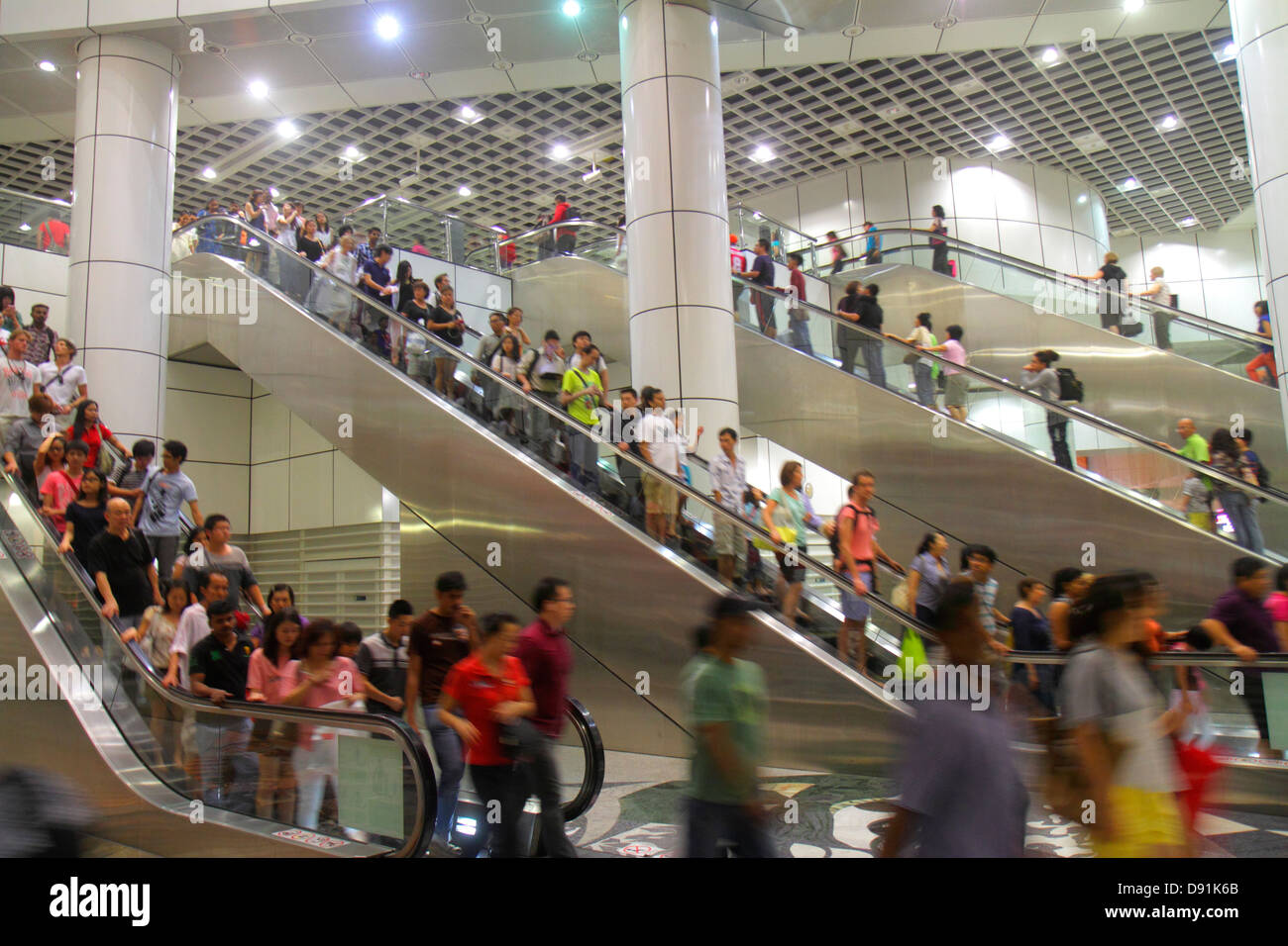 Singapore,Dhoby Ghaut MRT Station,North South Line,subway train,public transportation,escalator,riders,commuters,Asian Asians ethnic immigrant immigra Stock Photo