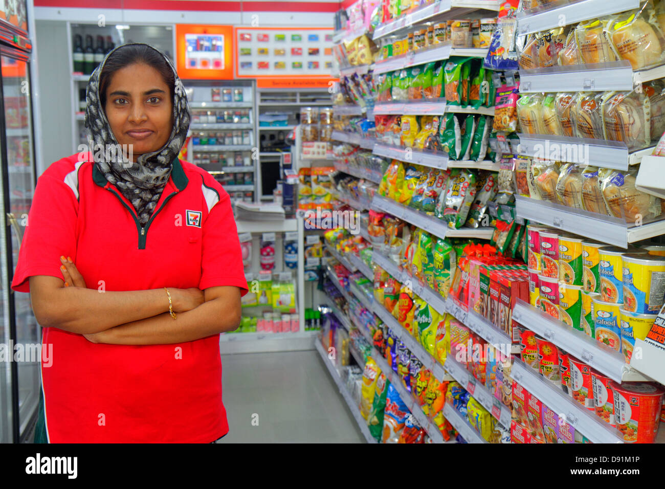 Singapore Kampong Glam,Muslim Quarter,Arab Street,7-Eleven,convenience,store,interior inside,Asian woman female women,Muslim,hijab,manager,job,working Stock Photo