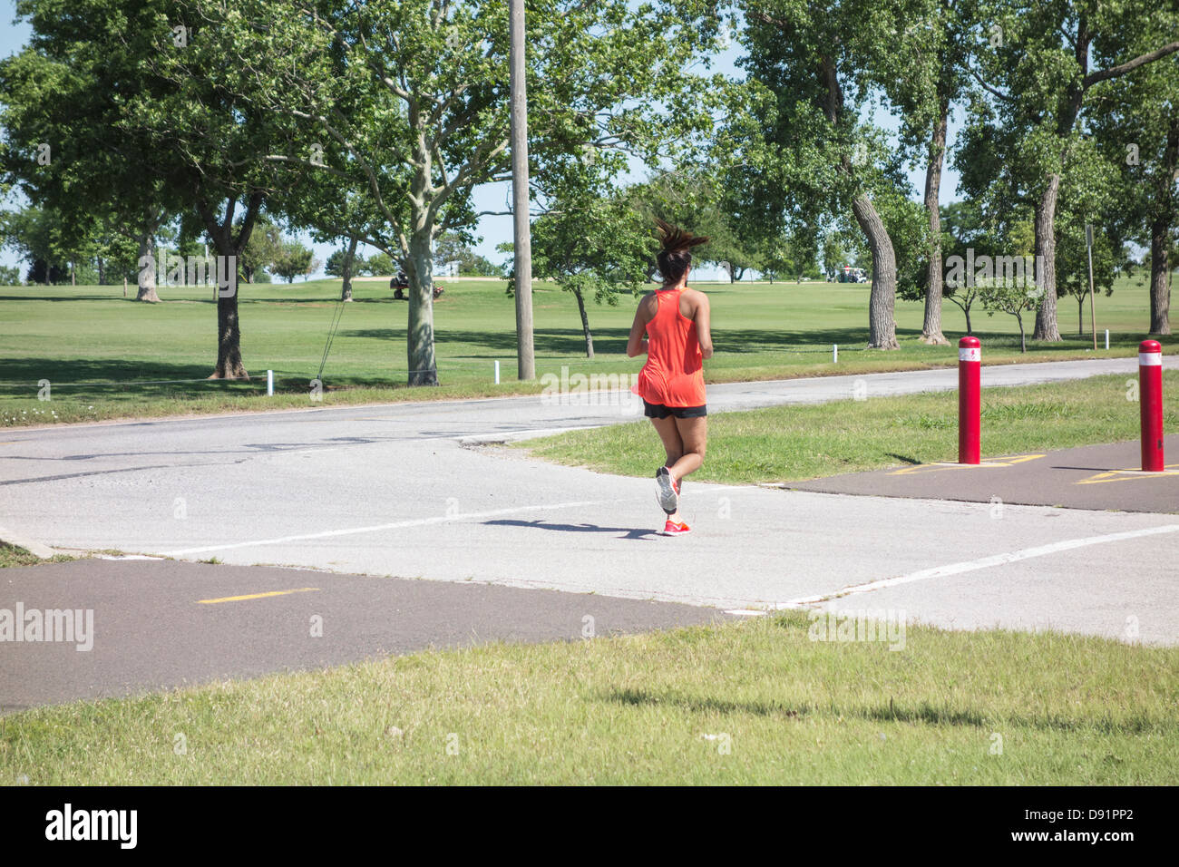 A woman in her 30s jogs along public trails at Lake Hefner in Oklahoma City, Oklahoma, USA. Stock Photo
