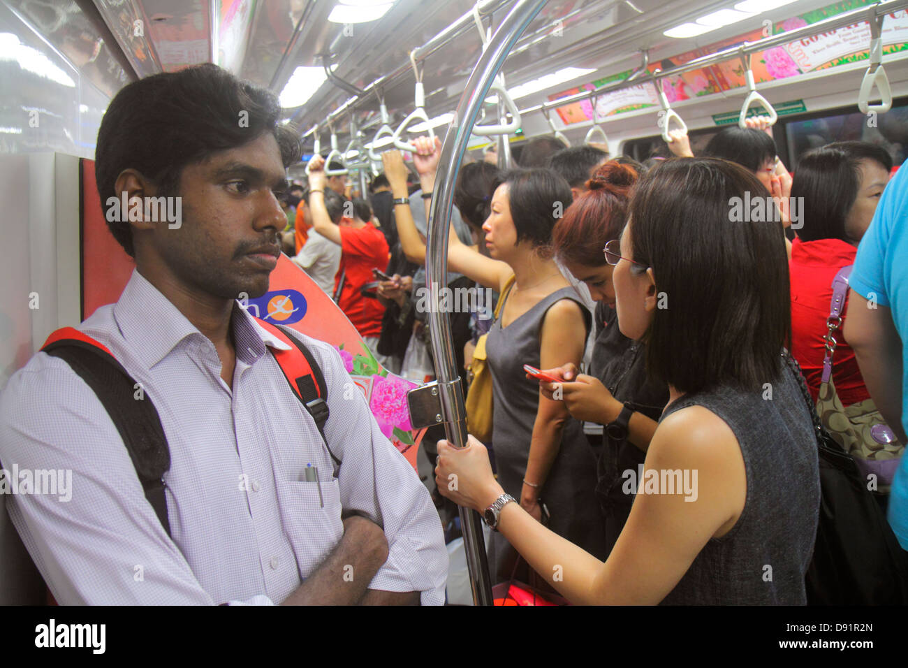 Singapore Orchard MRT Station,North South Line,subway train,riders,commuters,Asian man men male,woman female women,standing,passenger cabin,Sing130205 Stock Photo