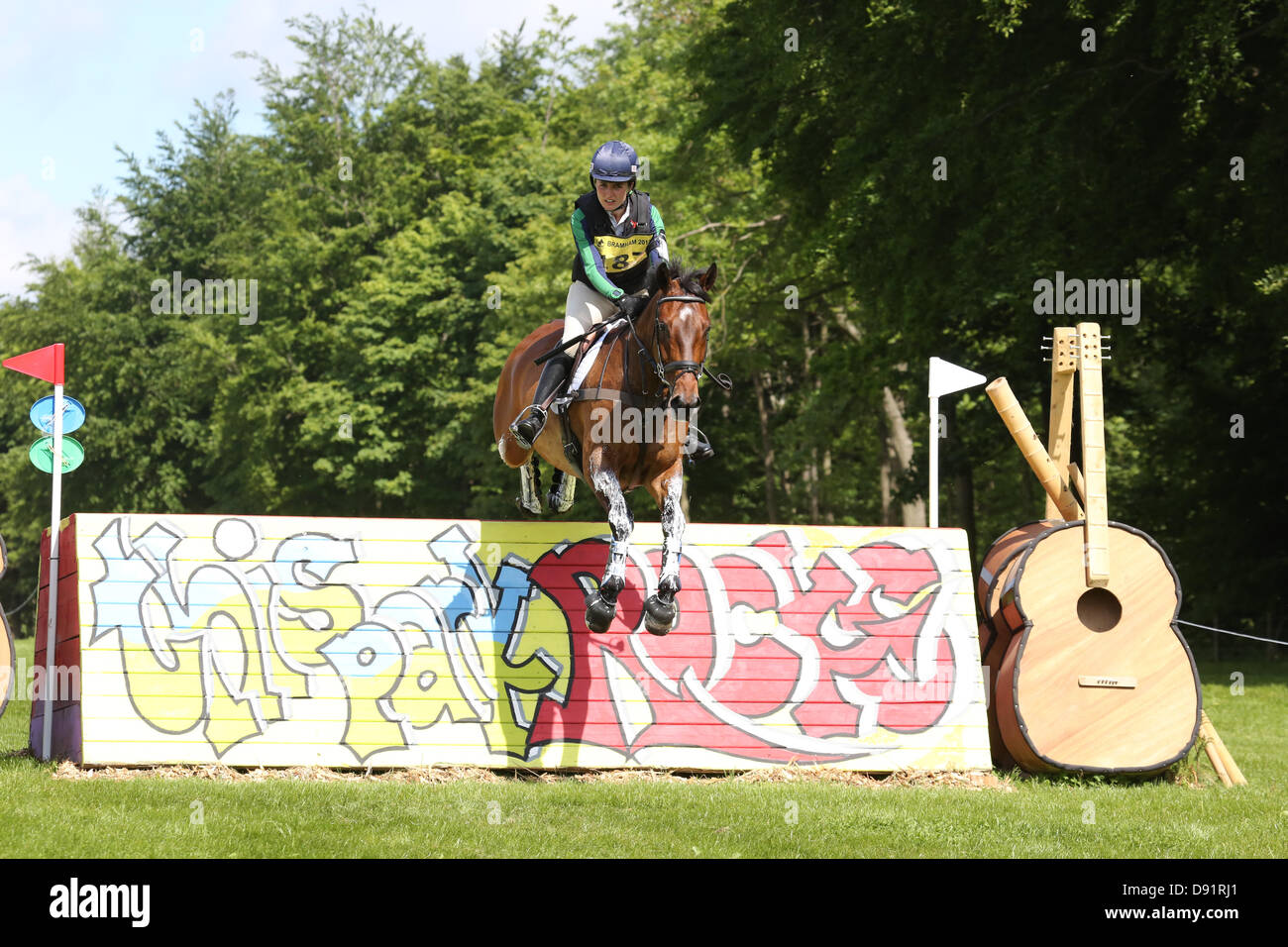 Leeds Bramham UK. 8th June 2013. Millie Dumas riding Action packed clears the Leeds Festival jump during the cross country event at the 40th Bramham horse trials, the annual Leeds Festival is held at the same site in August. Credit: S D Schofield/Alamy Live News Stock Photo