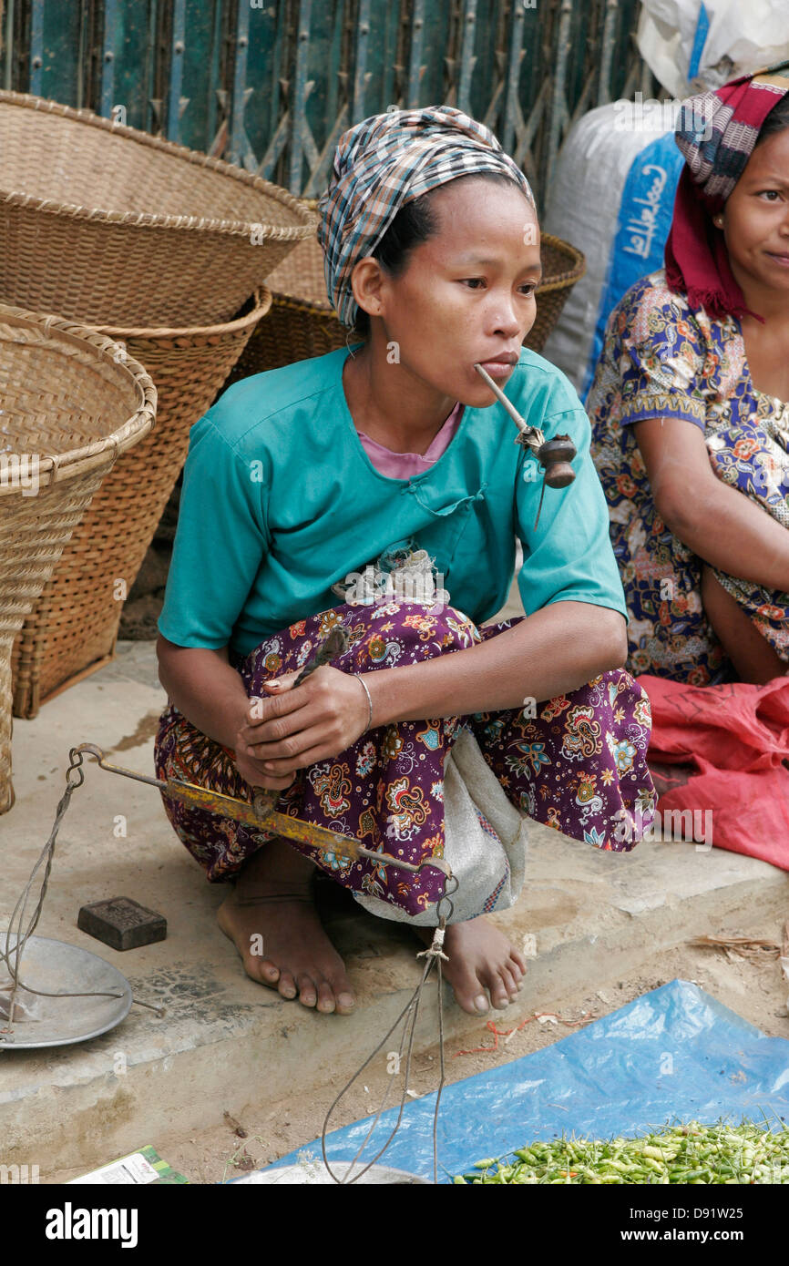 Tribal women smoking traditional pipe on the vegetable market in Ruma Bazaar, Chittagong Hill Tracts, Bangladesh Stock Photo