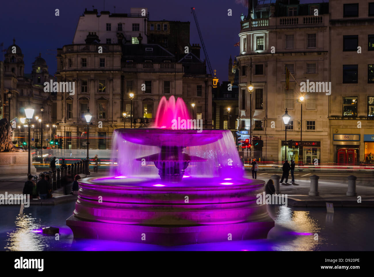 Trafalgar Square fountain illuminated at night. London, England. Stock Photo