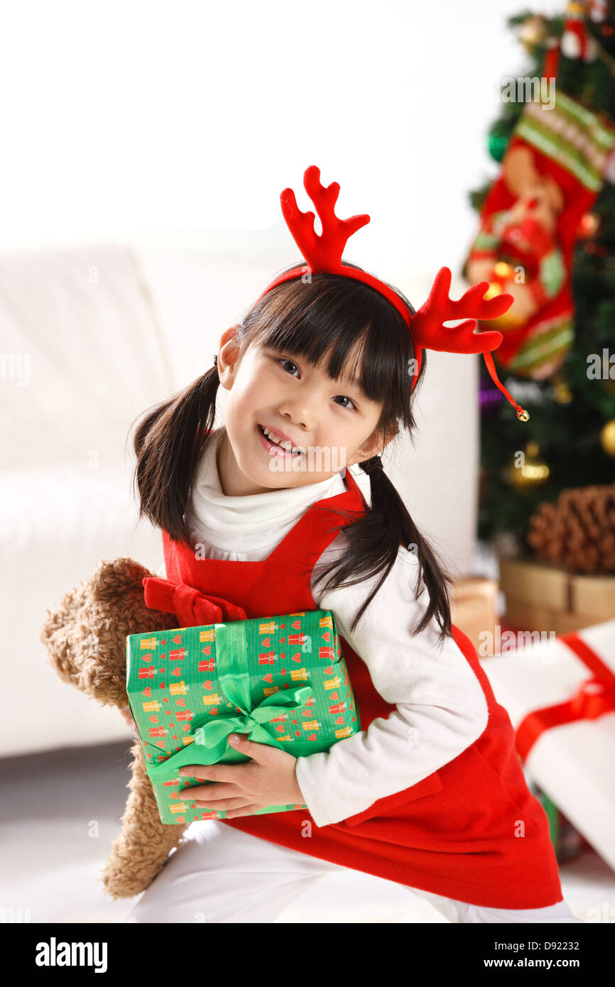 Girl holding Christmas gift Stock Photo - Alamy