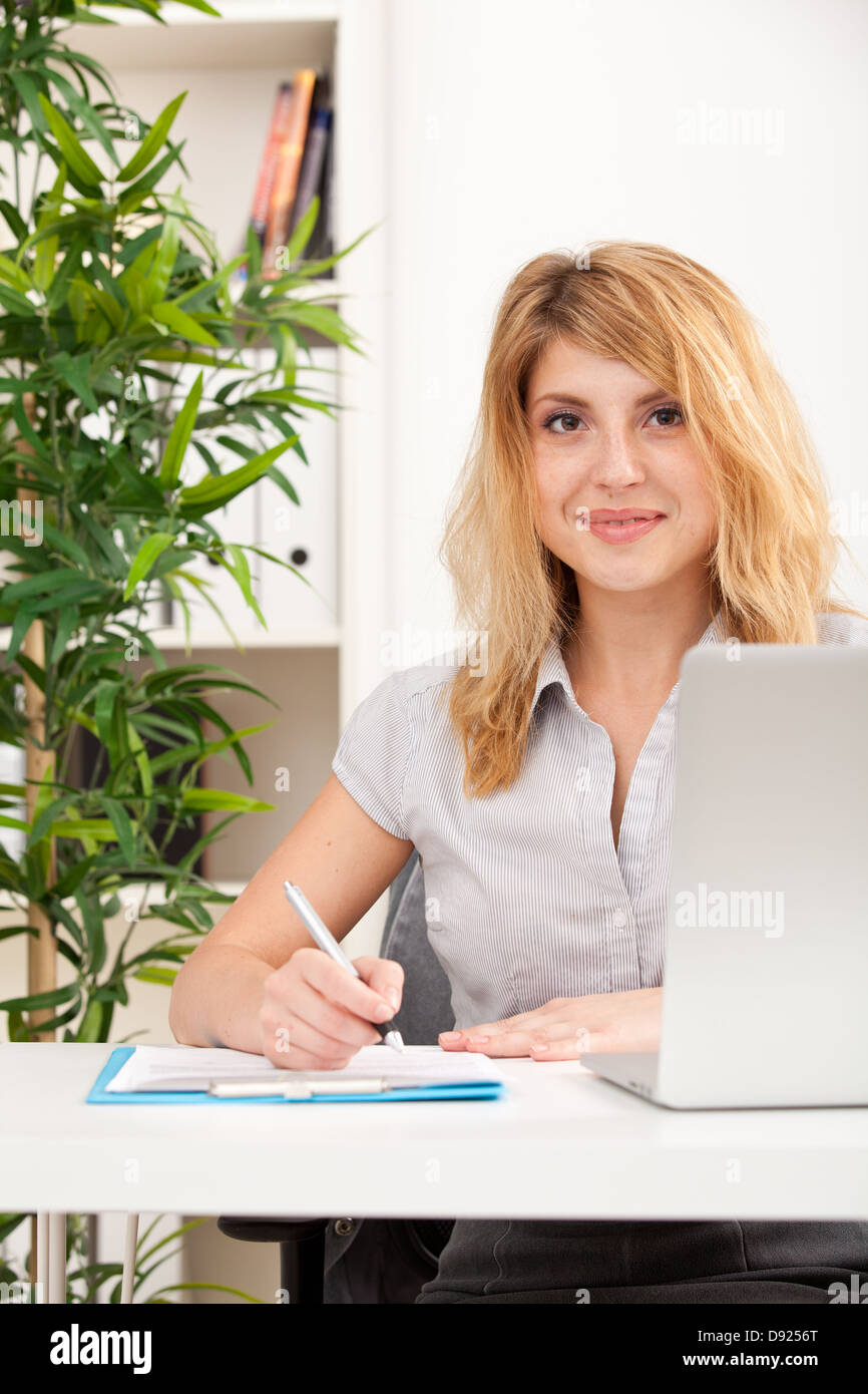 Portrait of a beautiful business woman working on her desk in an office ...