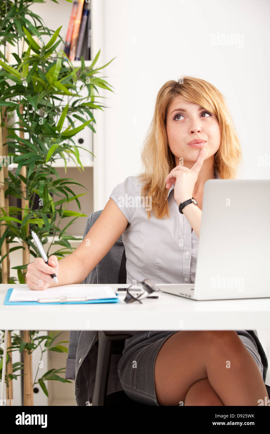 Portrait of a beautiful business woman working on her desk in an office ...