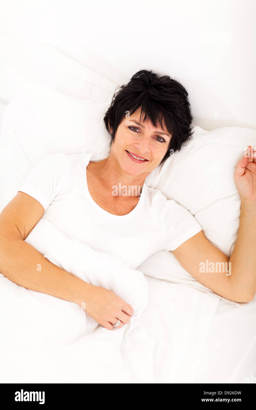 overhead view of elegant mid age woman lying on bed relaxing Stock Photo