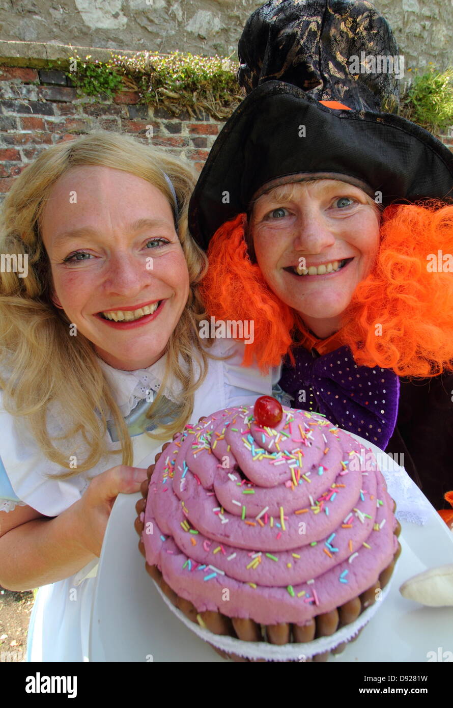 Bakewell, Derbyshire, UK. 9th June 2013. Bakewell Baking Festival. Anni Tosh (Alice), and Alison Benefield (Mad Hatter), from Story Bag Theatre Company, ditch tea for a giant cup-cake, Mad Hatter's Tea Party. Credit:  Deborah Vernon/Alamy Live News Stock Photo