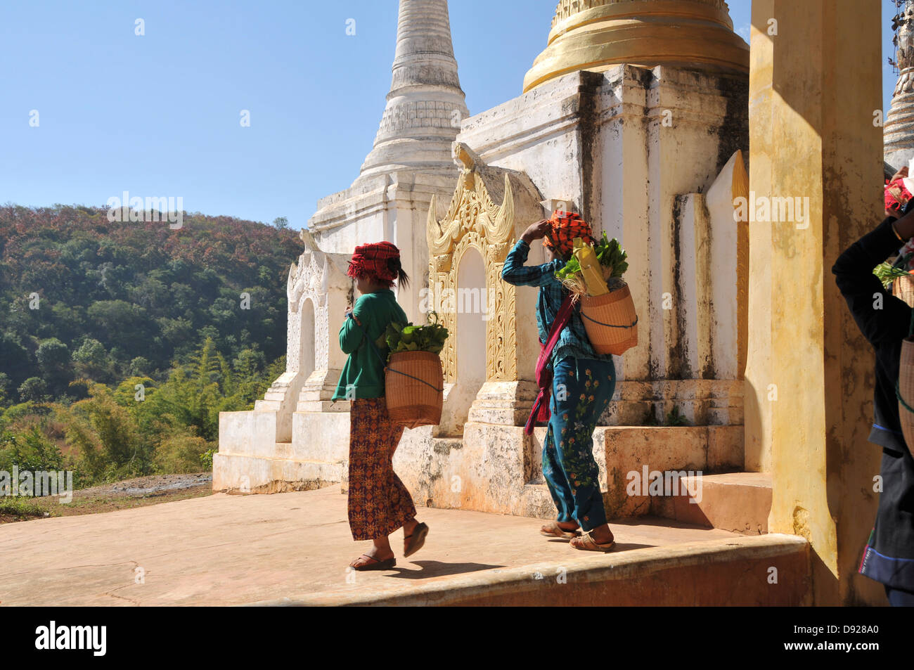 Pa-O women returning from market in front of Stupas of Thaung Tho Kyaung Pagoda, Inle Lake, Shan State, Myanmar Stock Photo
