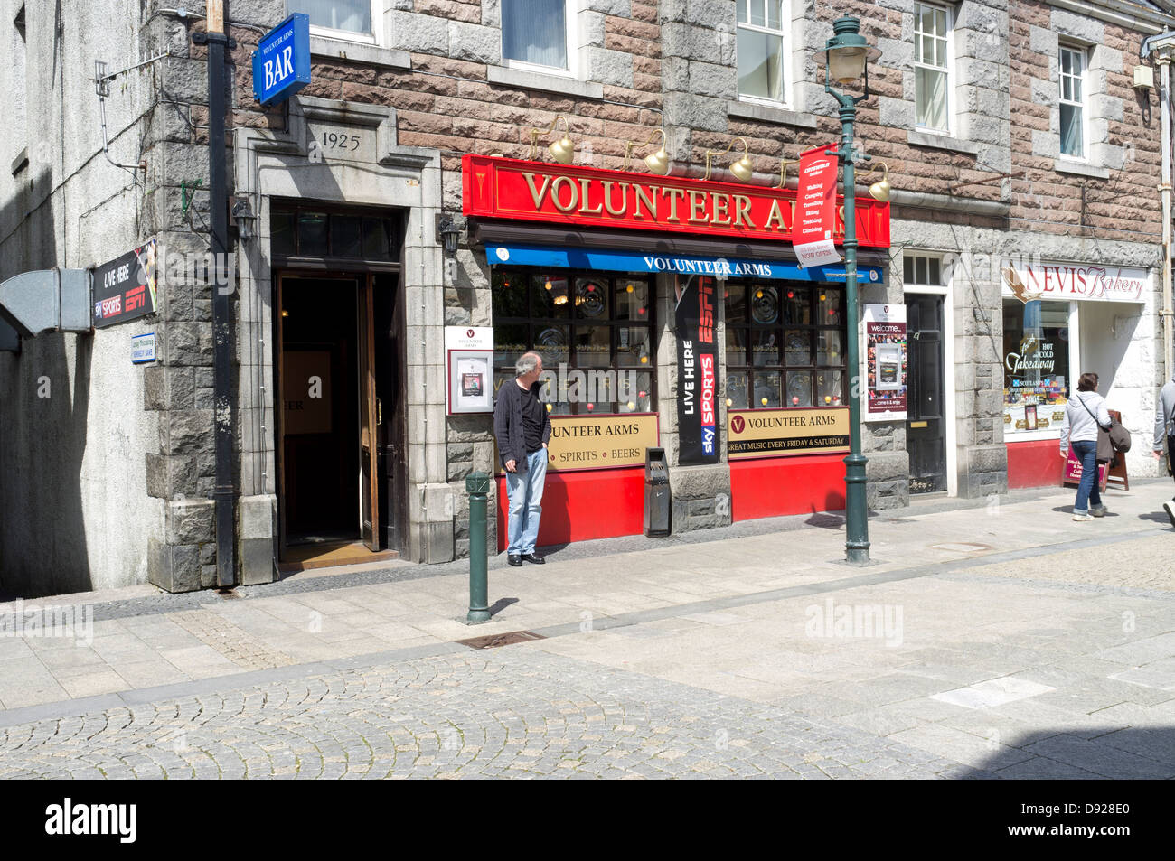 A smoker outside The Volunteer Arms bar Fort William main street Highlands Scotland UK Stock