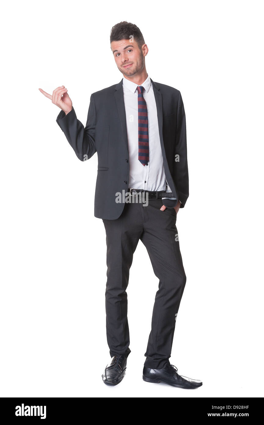 Happy young businessman, full length, pointing to side, isolated on white Stock Photo