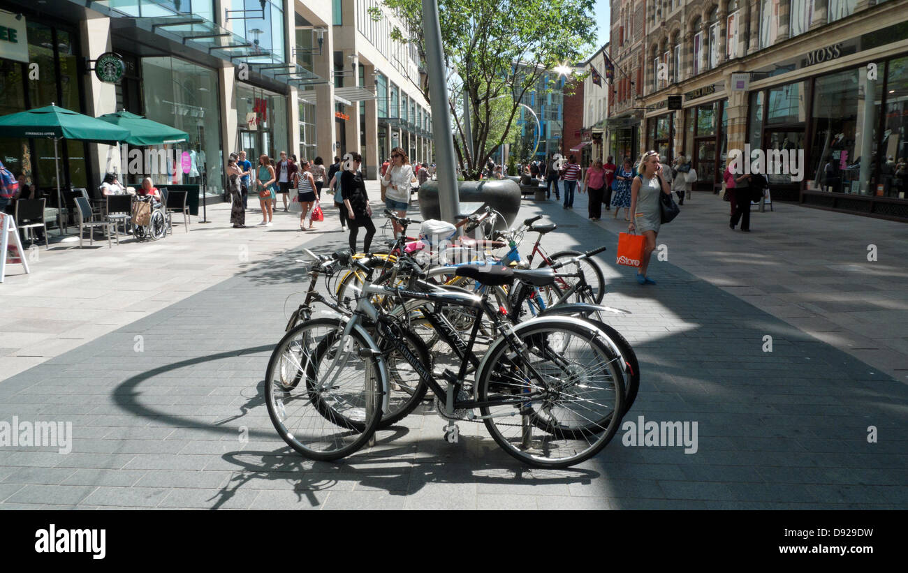Bikes parked in St David's 2 main pedestrianised shopping street and people shoppers walking in summer Cardiff City Centre Wales UK    KATHY DEWITT Stock Photo