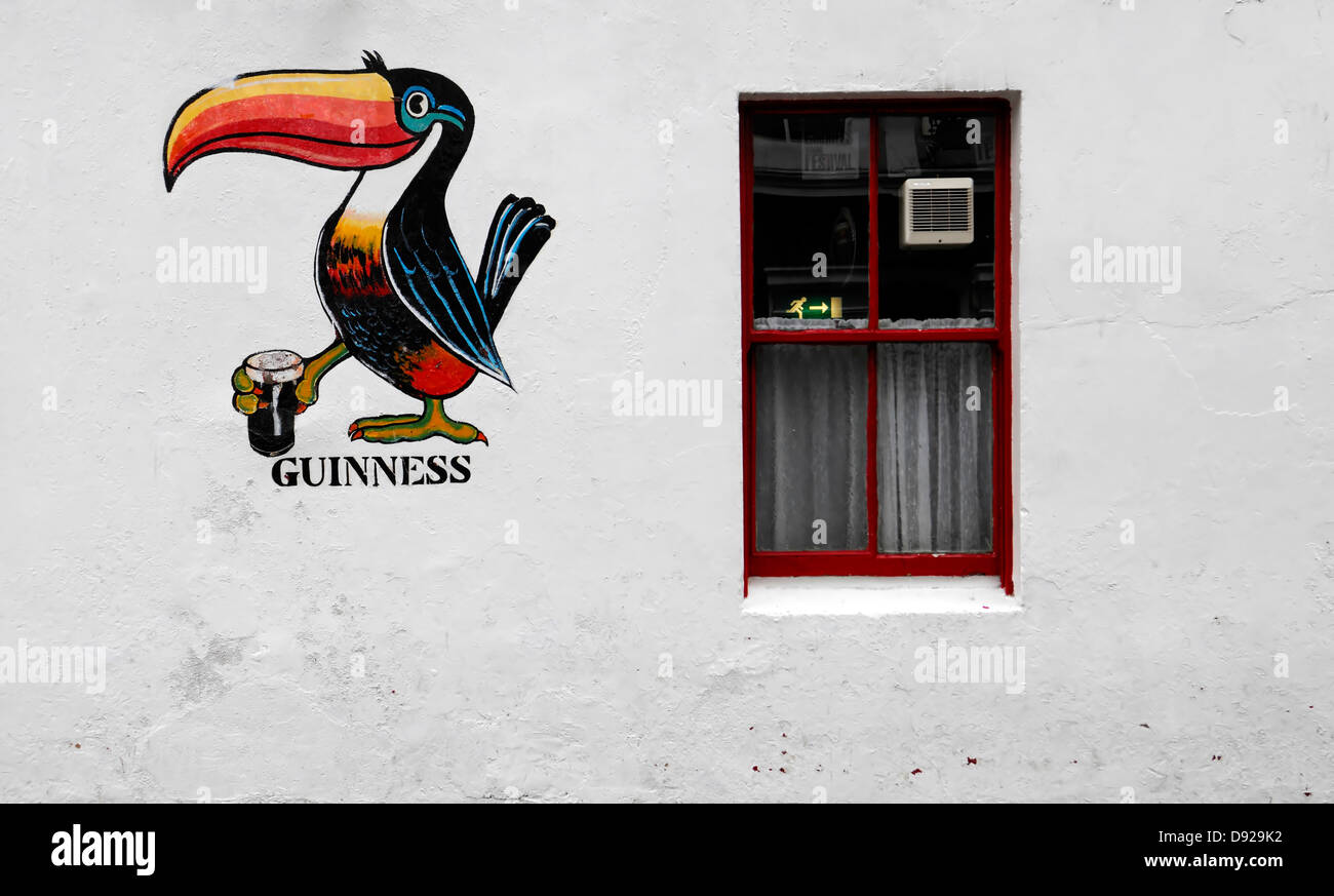Guinness Toucan painting mural image The Dewdrop Inn bar pub licensed premises galway ireland white wall public house Stock Photo