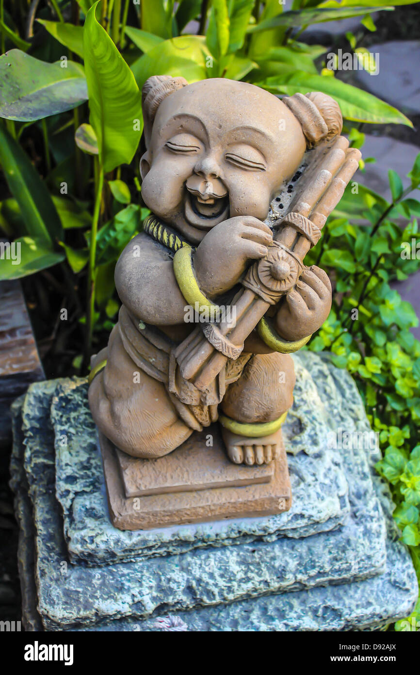 The child pottery play the bamboo mouth organ in the garden Stock Photo
