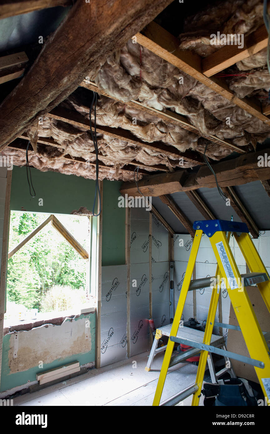 Loft and wall insulation being installed in a cottage Stock Photo