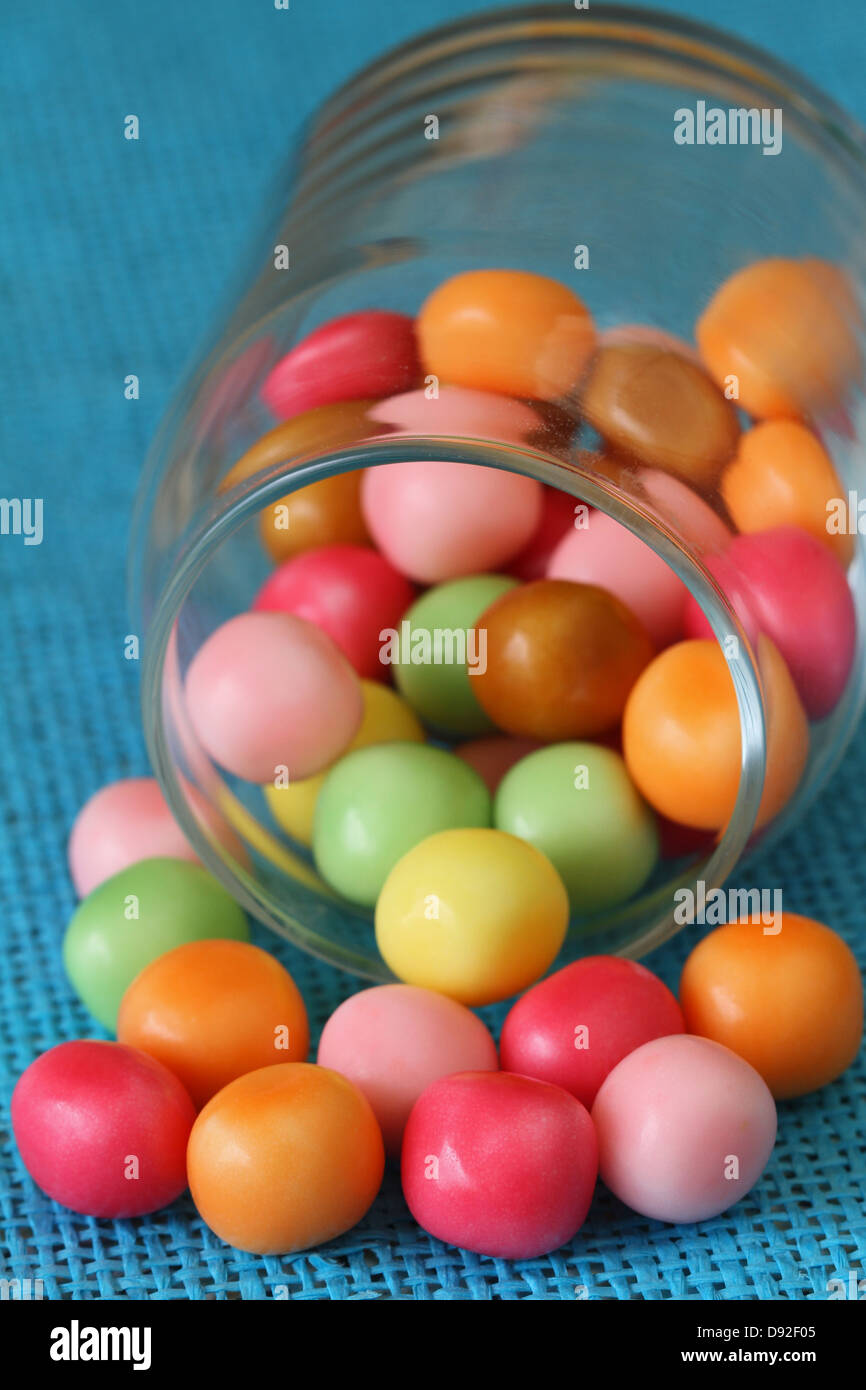 Colorful candy in glass jar on blue background Stock Photo - Alamy