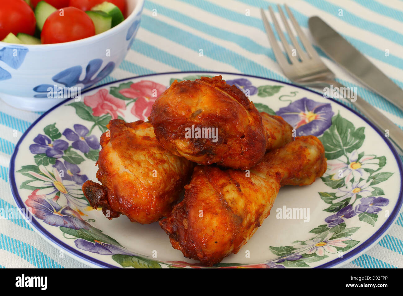 Roasted chicken drumsticks on vintage plate Stock Photo