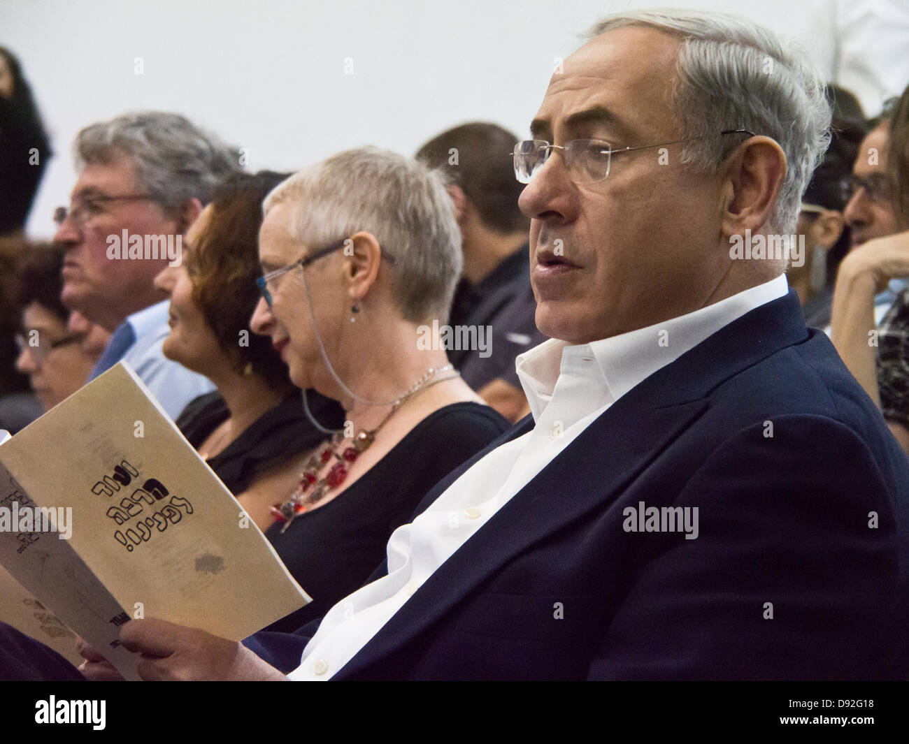 Prime Minister BENJAMIN NETANYAHU browses through the evening's program as he attends son's high school graduation ceremony. Jerusalem, Israel. 9-June-2013.  Prime Minister Benjamin Netanyahu and wife Sarah Netanyahu attends son's high school graduation ceremony. Stock Photo
