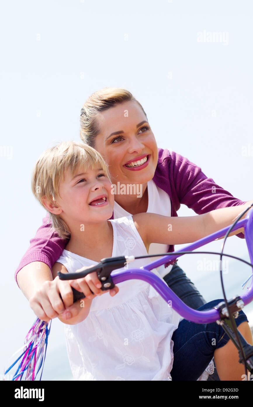 low angel view of happy mother teaching daughter how to ride a bicycle Stock Photo