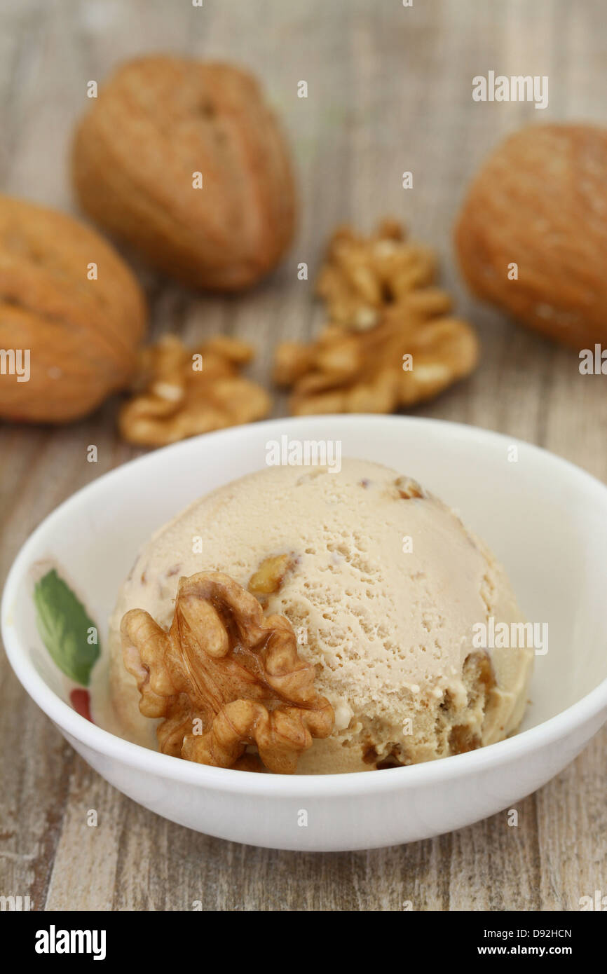 Walnut ice cream scoop in porcelain bowl Stock Photo