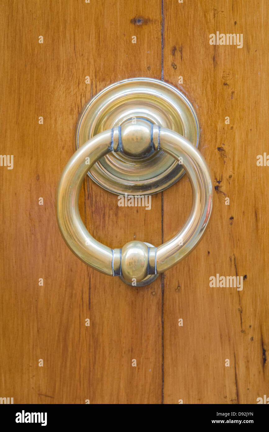 Shiny, metal door knocker on a wooden door Stock Photo Alamy