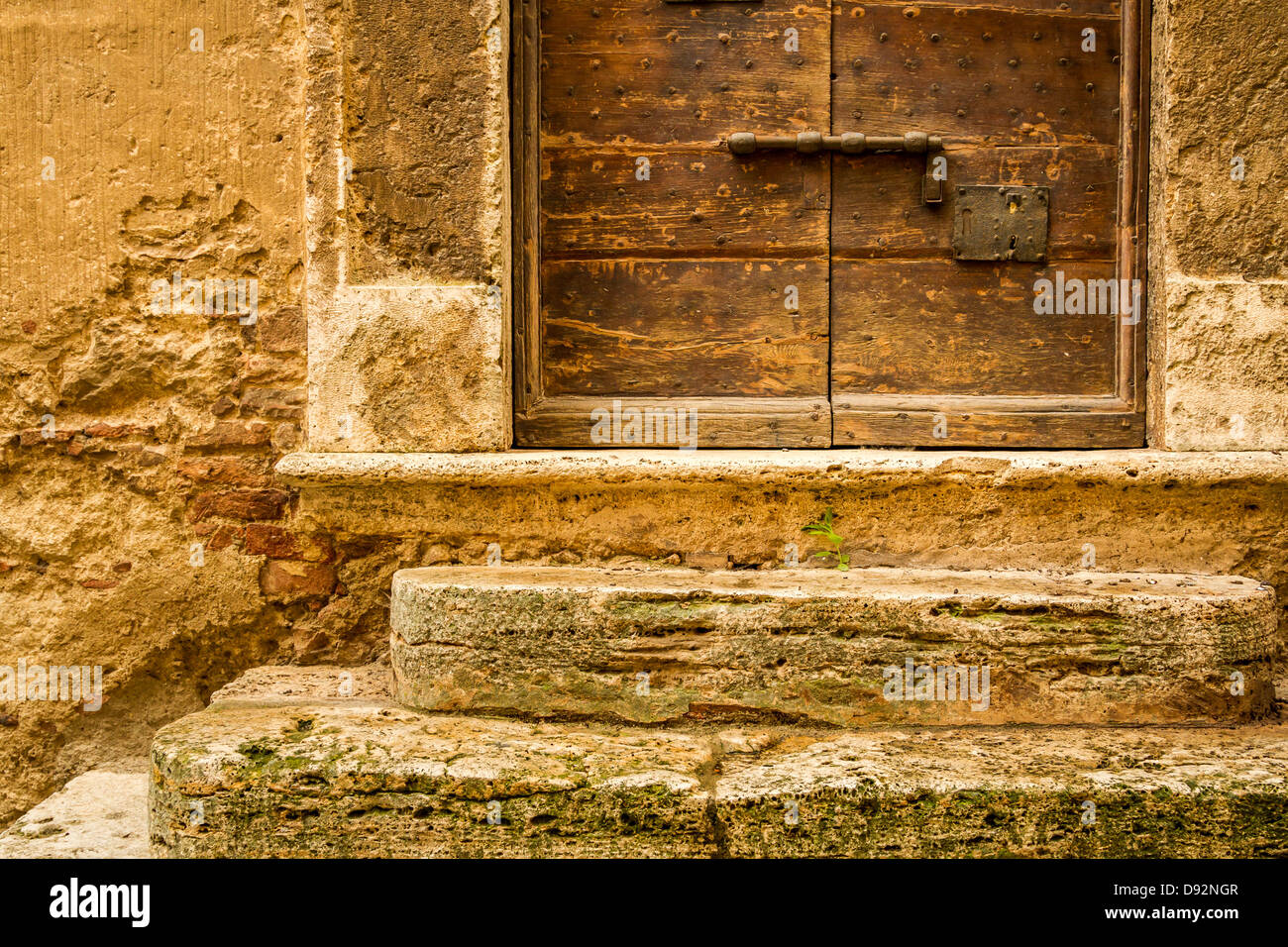 Old wooden door with medieval wall background Stock Photo - Alamy