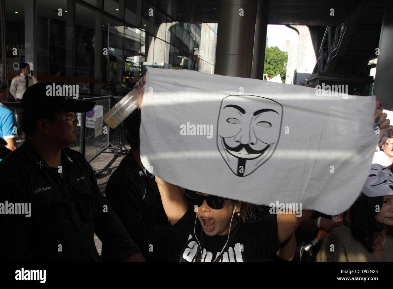 Bangkok , Thailand. 9th June 2013. A protester holding Guy Falkes white mask poster during rally . Protesters wearing "Guy Fawkes" continue to rally in Bangkok and others parts of Thailand against the Yingluck Shinawatra government, which opponents say is a "puppet" regime controlled by fugitive former premier Thaksin Shinawatra. Credit:  John Vincent/17�Թ����� Live News Stock Photo