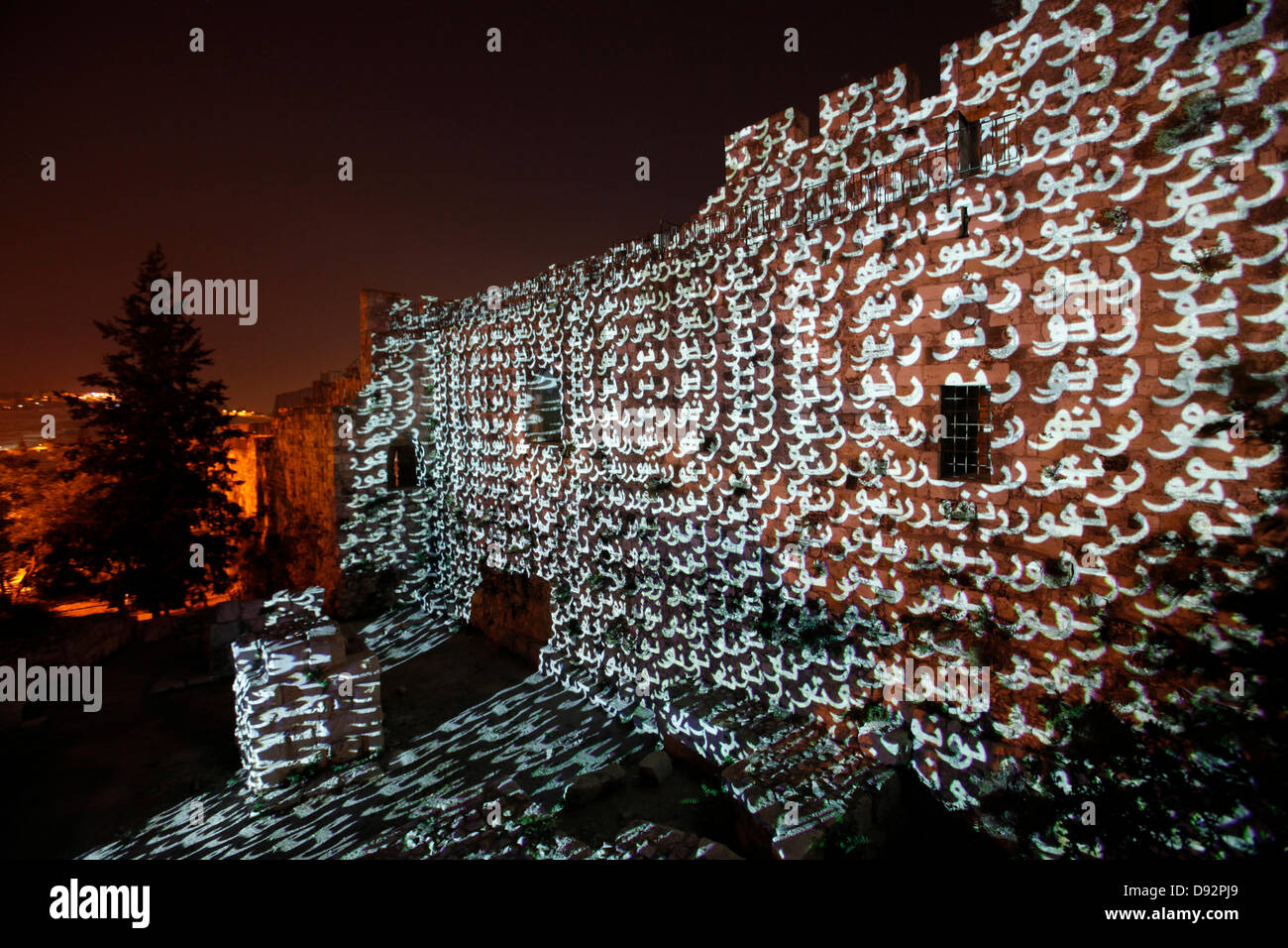 The word Light in Arabic is projected onto old city walls during the Jerusalem Festival of Light in Israel which takes place annually around the old city with special effects illuminating historical sites and displays the work of leading international artists. Stock Photo